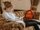 Ein Teenager sitzt auf einem Sofa und scrollt auf dem Smartphone.