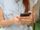 Eine junge Frau hält ein Smartphone in den Händen