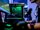 Ein Person sitzt vor einem leuchtenden Gaming-PC an einem Bildschirm.