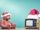 Ein Teddy mit Weihnachtsmütze sitzt vor gelbem Fernseher mit Weihnachtsmütze