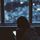 Ein Maedchen sitzt in einem dunklen Zimmer und schaut auf ihr Smartphone