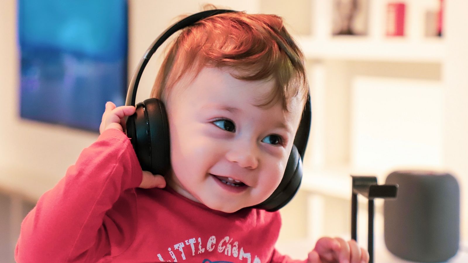 Ein kleines Kind mit großen kopfhörern sieht glücklich aus