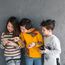Drei Kinder schauen auf ihre Smartphones