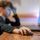 Braunhaariger Junge sitzt seitlich vor einem Computer-Bildschrim