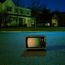 Alter Fernseher steht nachts auf leerer Straße im Wohnviertel