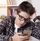 Ein Junge guckt gelangweilt auf ein Smartphone