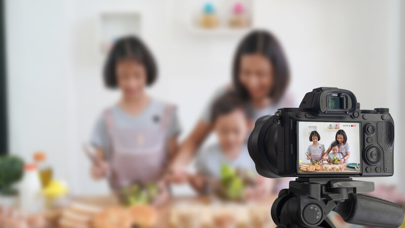 Kind, Mutter und Tochter kochen und filmen sich dabei