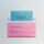 Ein blauer Stimmzettel steckt in einem pinken Wahlbriefumschlag.