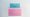 Ein blauer Stimmzettel steckt in einem pinken Wahlbriefumschlag.