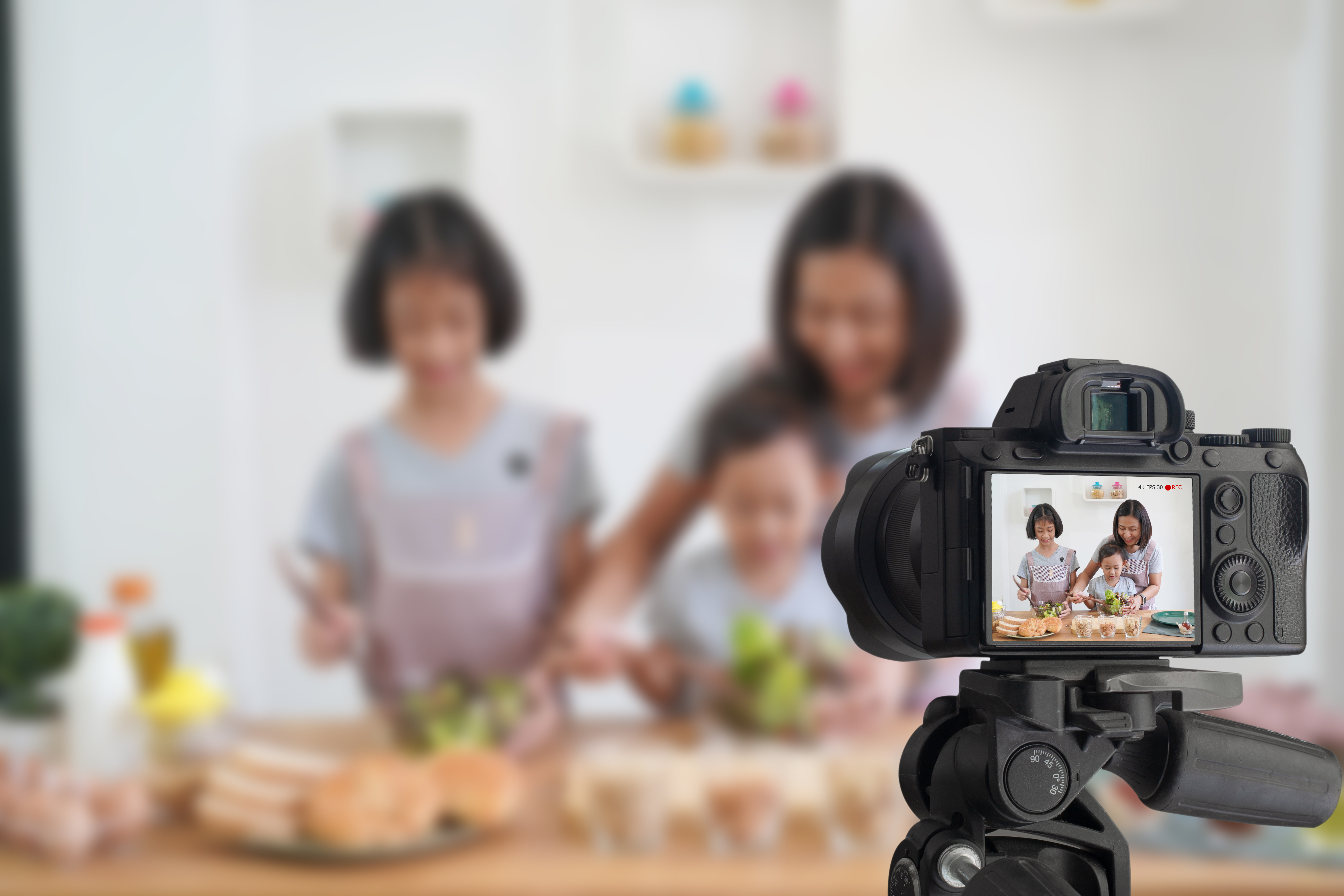Kind, Mutter und Tochter kochen und filmen sich dabei