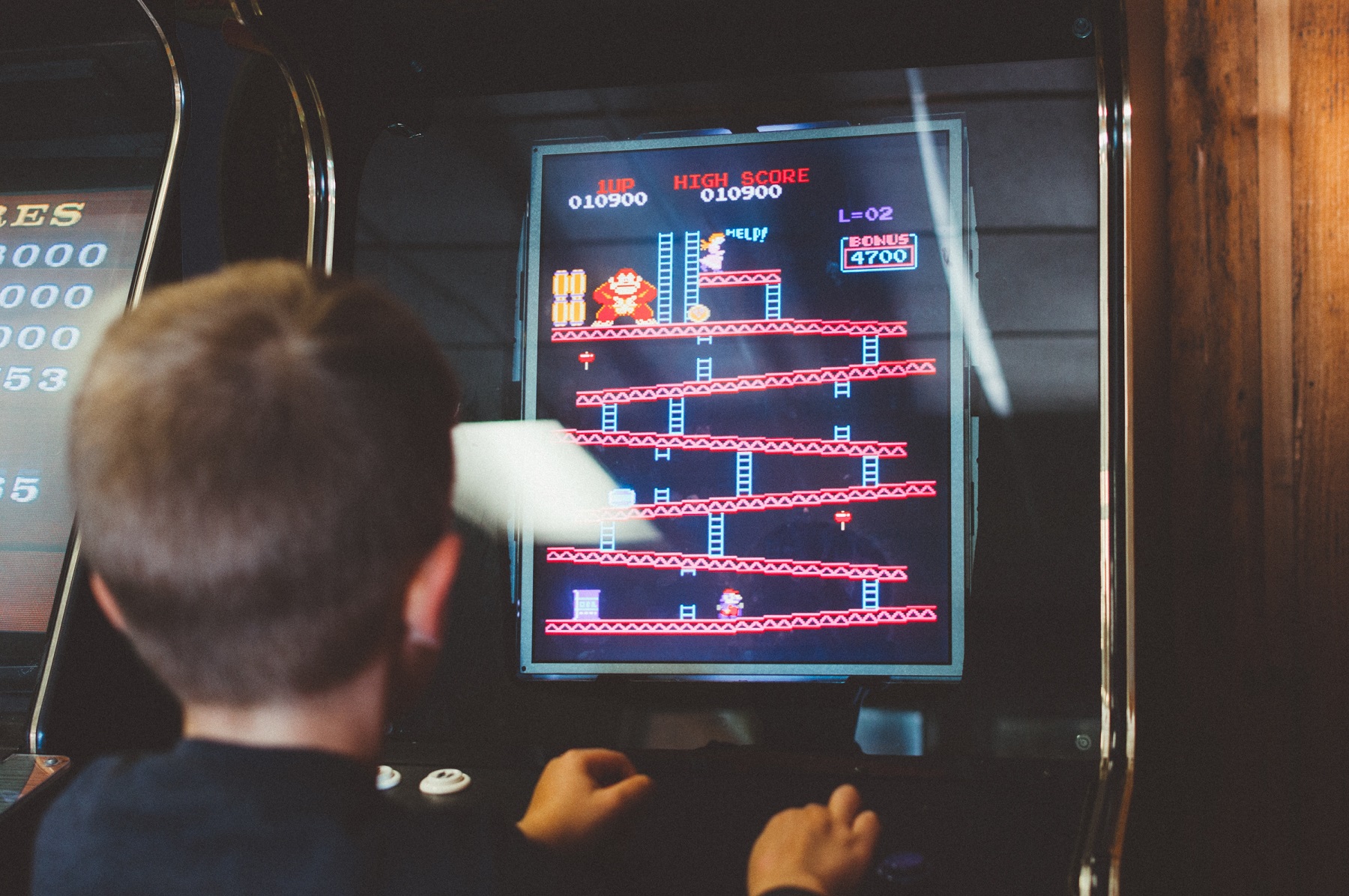 Ein Junge spielt an einem alten Spielautomat