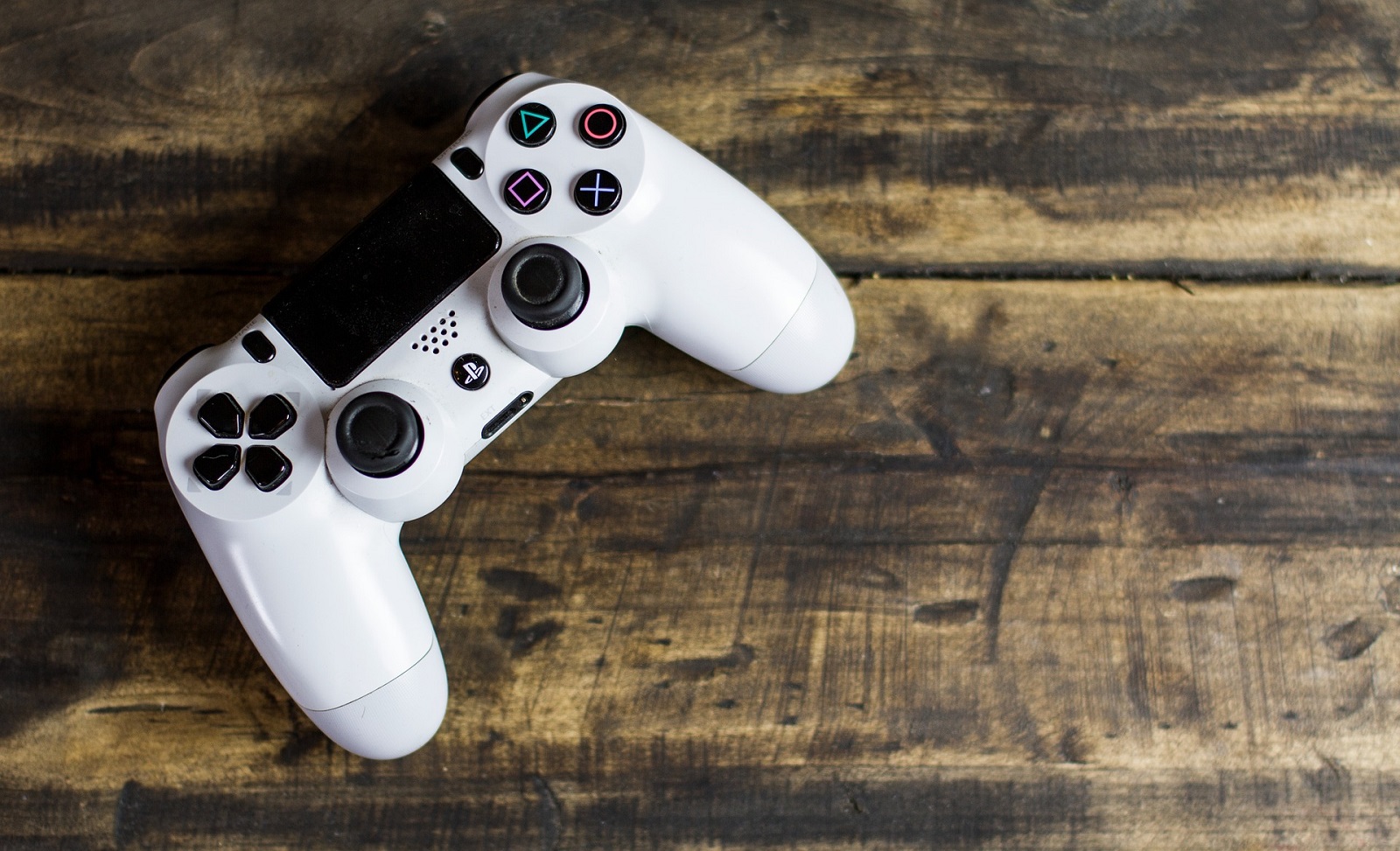 Ein Playstation Controller liegt auf Holz