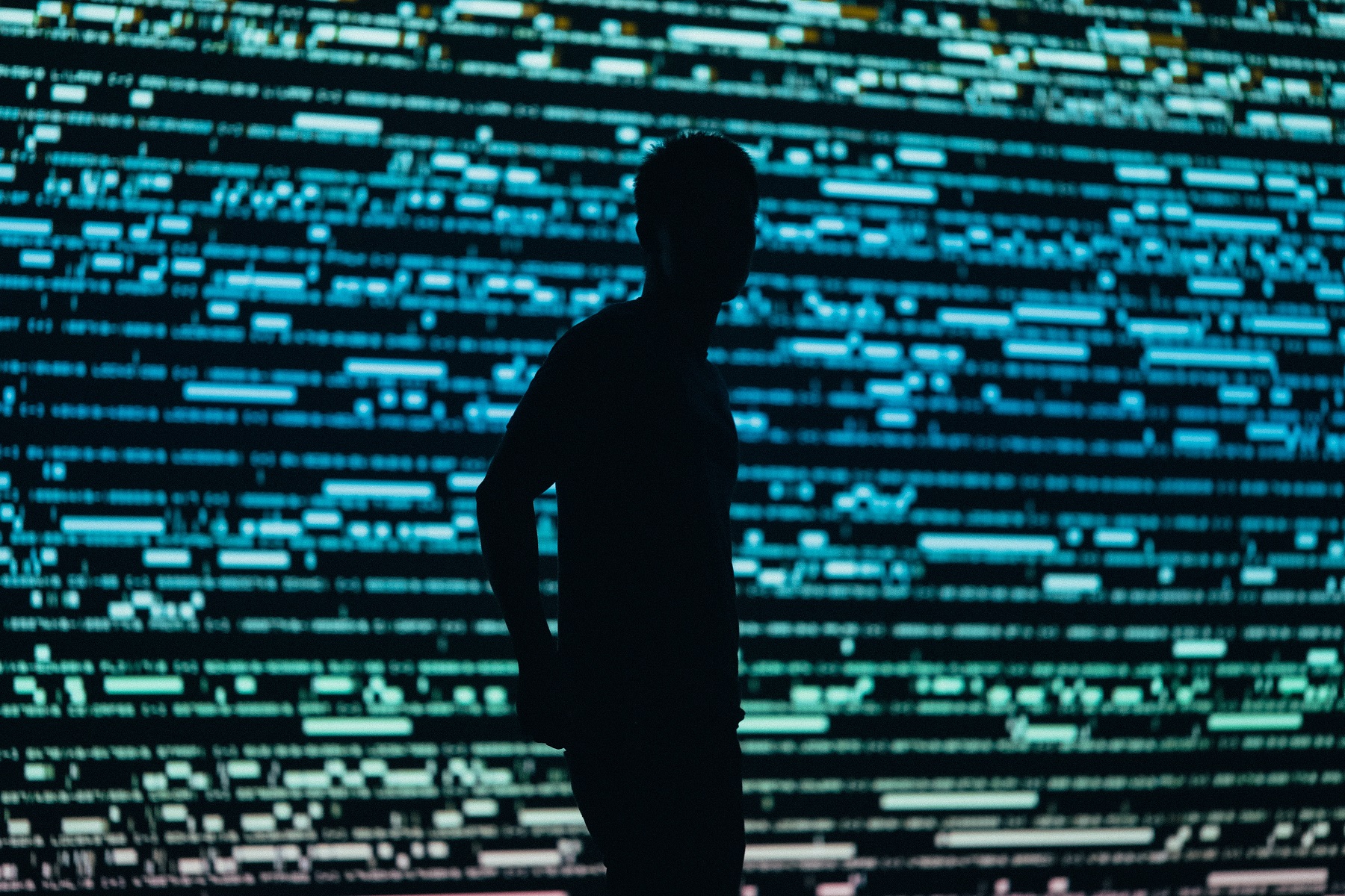 Silhouette eines Mannes vor einem Bildschirm voller Daten