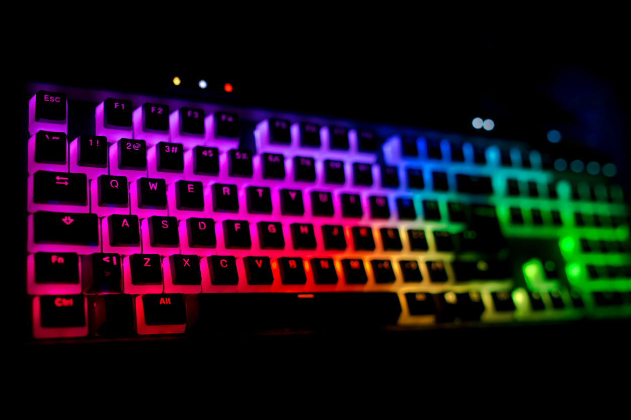eine in pink, lila, blau und grün leuchtende Gaming-Tastatur in der Dunkelheit