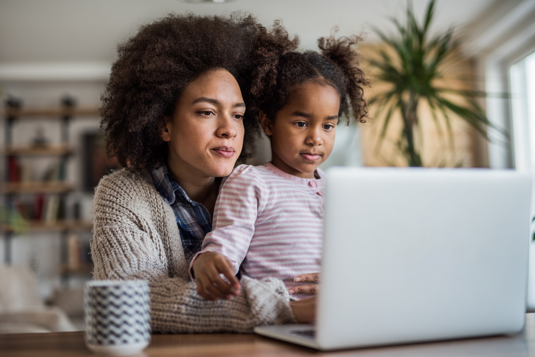 Mutter und ihre Tochter schauen auf einen Laptop