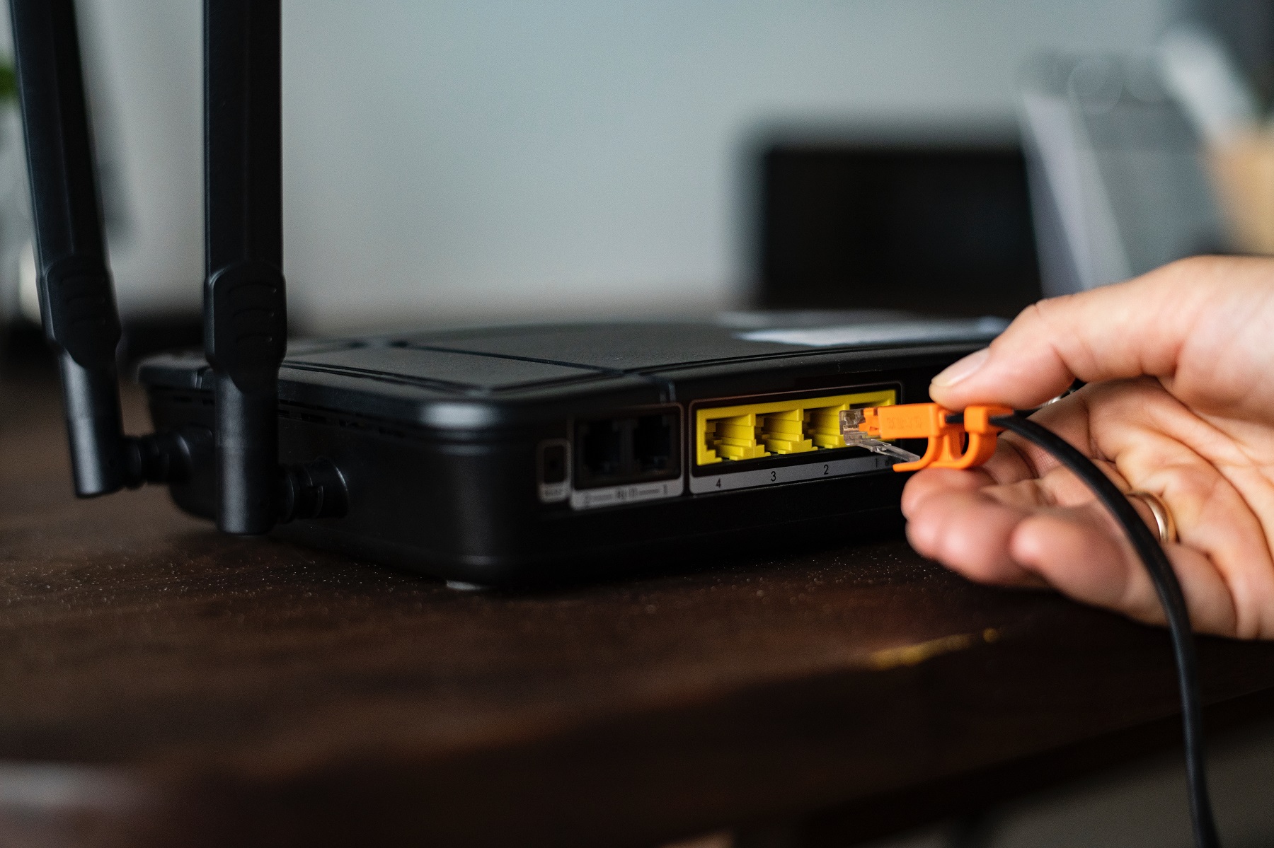 Hand steckt Lan-Kabel in den Router