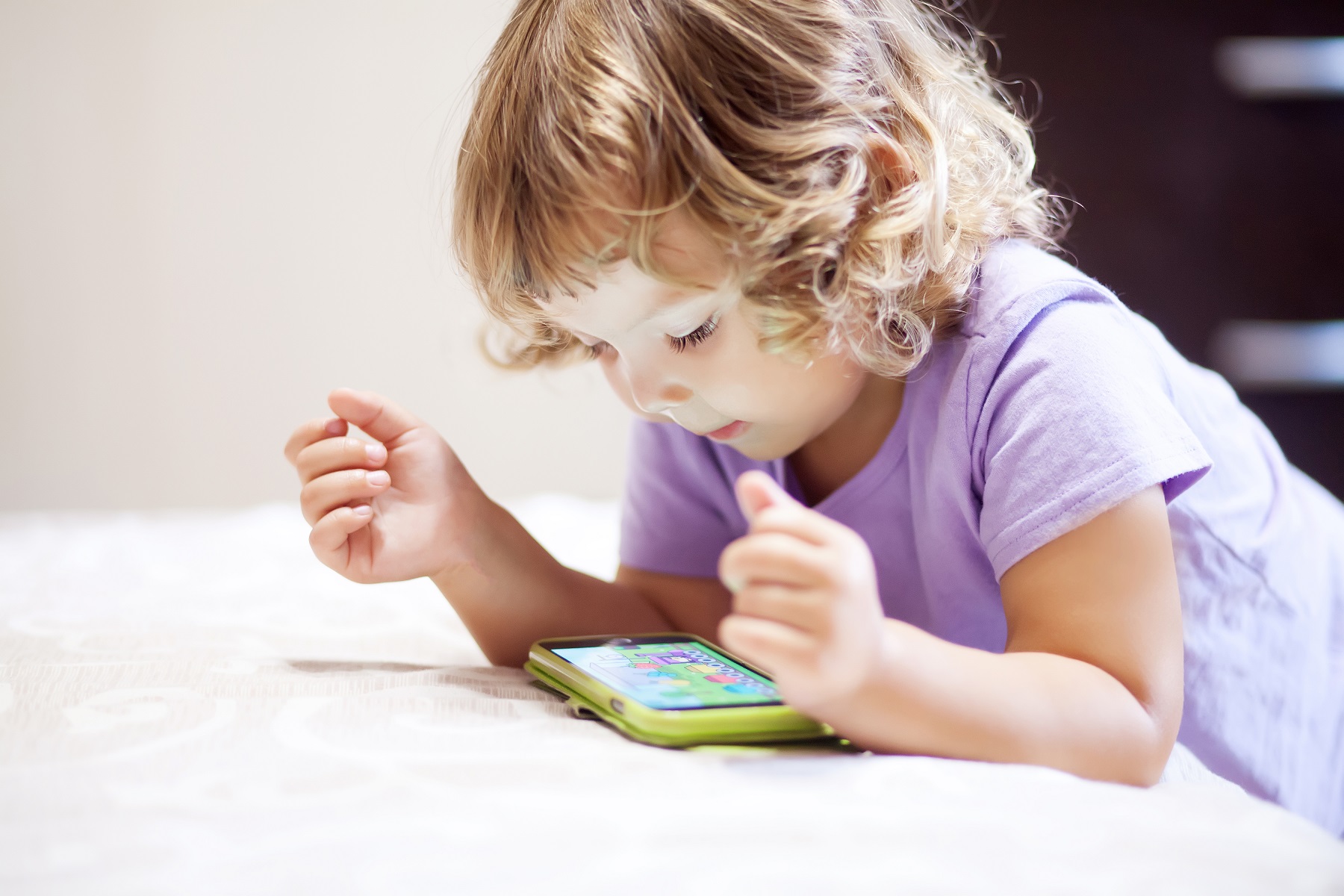 Kind spielt eine Spiele-App auf dem Smartphone