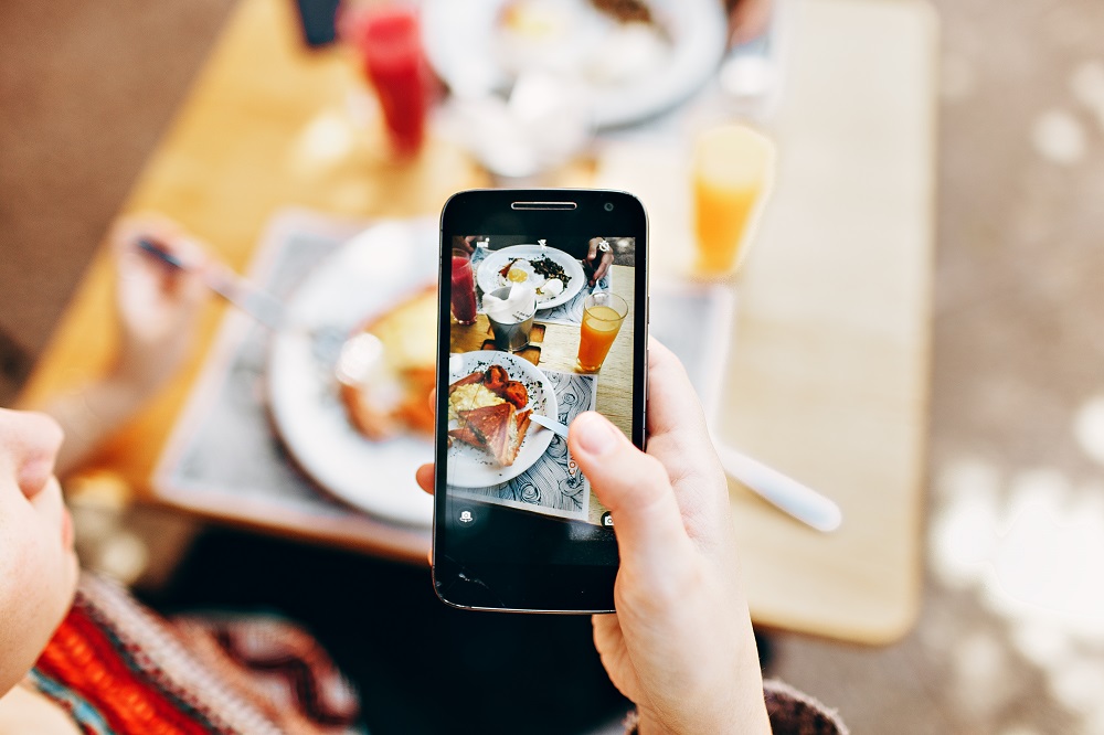 Eine Frau fotografiert ihr Essen