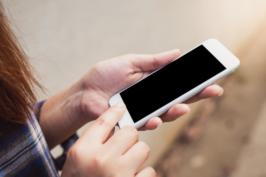 Eine Frau haelt ein Smartphone in der Hand