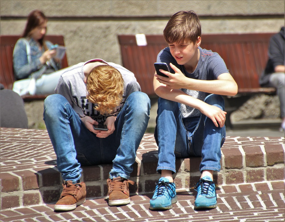 Zwei Junges schauen gebannt auf ihre Smartphones