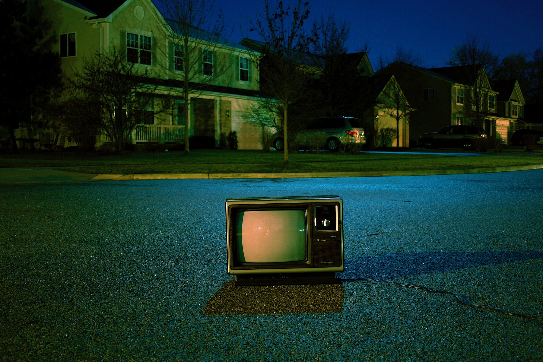 Alter Fernseher steht nachts auf leerer Straße im Wohnviertel