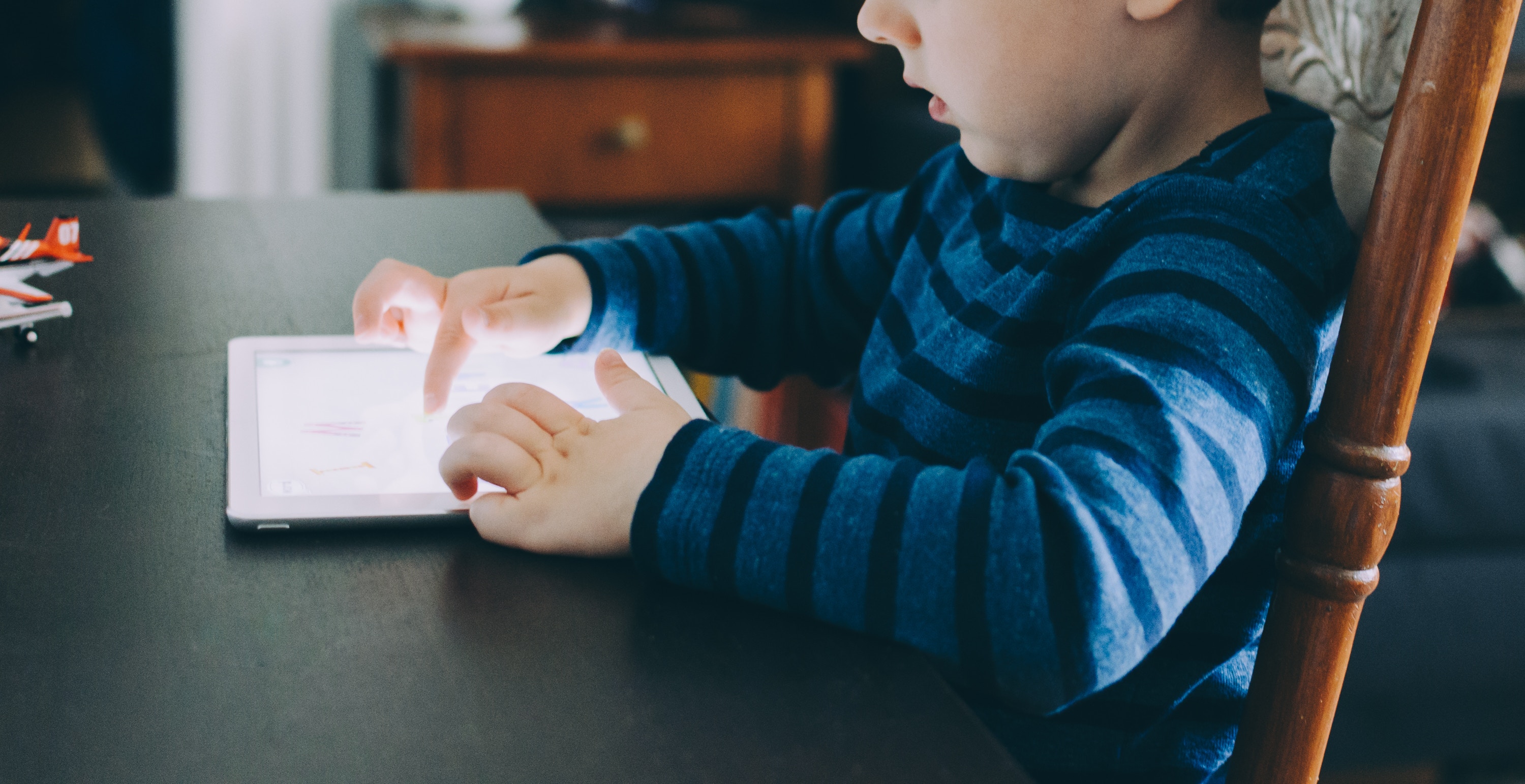 Ein kleiner Junge tippt auf einem Tablet
