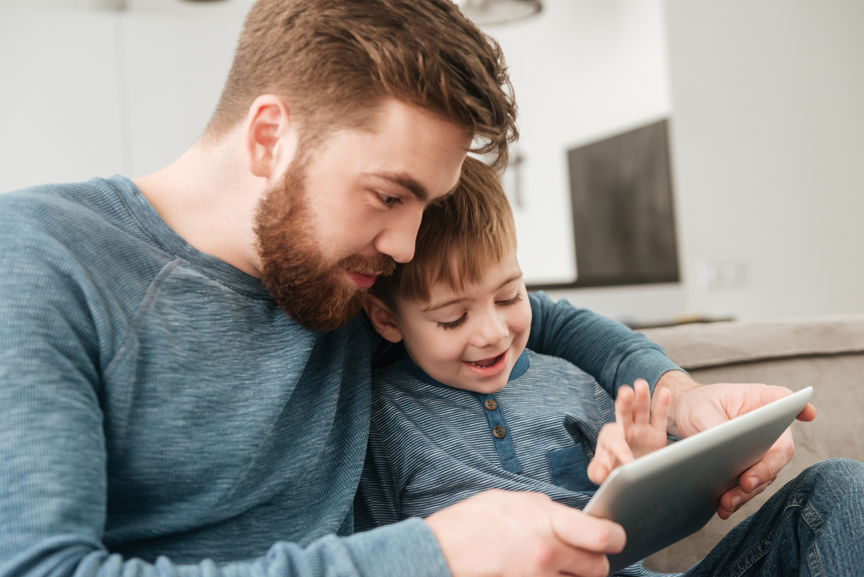 Vater und Sohn schauen gemeinsam auf ein Tablet